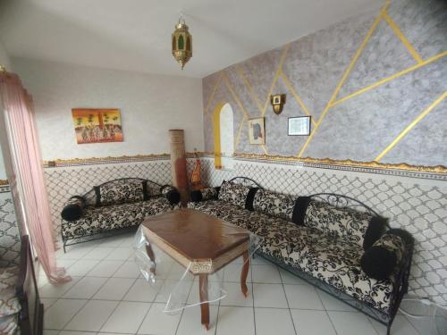 a living room with two couches and a table at Appartement complexe Arrous Bahr mikki beach vue piscine et jardin in Tangier