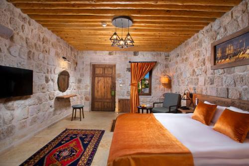 a bedroom with a large bed in a stone wall at Woox Cappadocia in Uçhisar