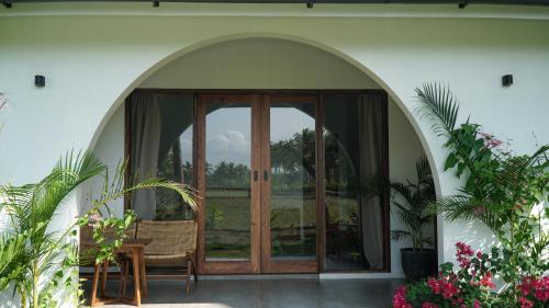 an arched entryway to a house with a glass door at Rumah Markisa Batukaras in Batukaras