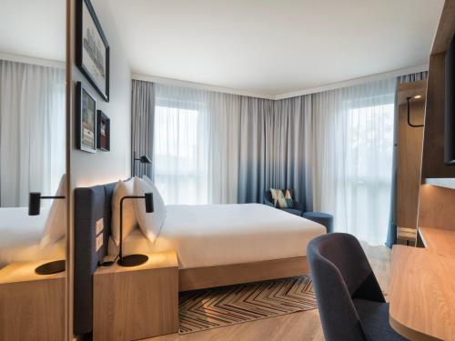 a hotel room with a bed and a tv at Hampton By Hilton Celle in Celle