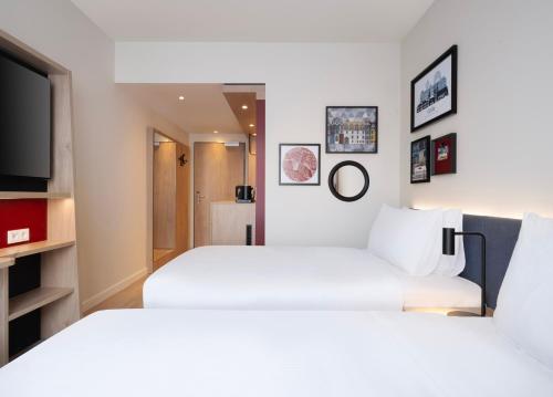 a hotel room with two beds and a tv at Hampton By Hilton Celle in Celle