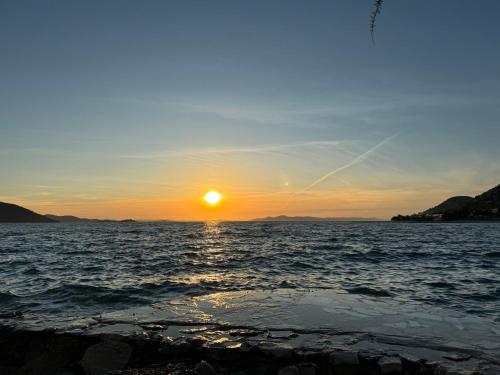 a sunset over a body of water with the sun setting at Marty House Drage in Drage