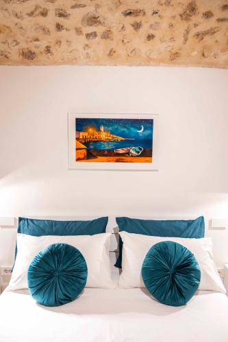a bedroom with a white bed with blue pillows at Castel Manfredi Apartments in Manfredonia