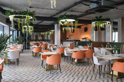 Laguna Beskidów Resort - Apartament A85 في زارجيتشه: مطعم به طاولات وكراسي ونباتات