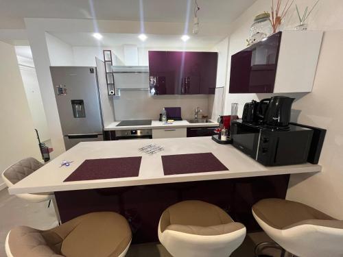 - une cuisine avec un comptoir blanc dans une pièce dans l'établissement Port Lympia - Grand 2 Pièces Confort, à Nice