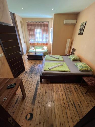 a bedroom with two beds and a table in it at Elegance on a Budget - Rooms for Rent in Sofia Center in Sofia