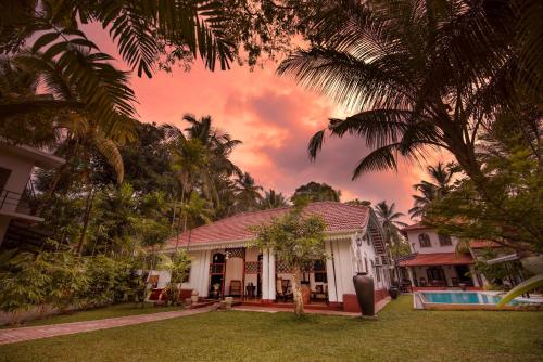 a house with a palm tree in the yard at Fortress de Jayaweera - Historic Villa Bentota - A proud legacy since 1889 in Bentota