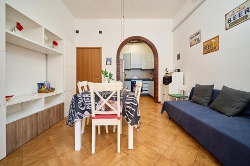 a living room with a table and a blue couch at Casabaffo in Piombino