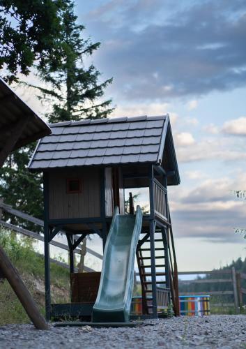 a playground with a slide and a house at Cabana Transylwonder in Sicasău