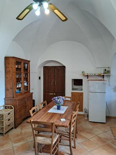 cocina con mesa de madera con sillas y nevera en Marosi, en Pantelleria