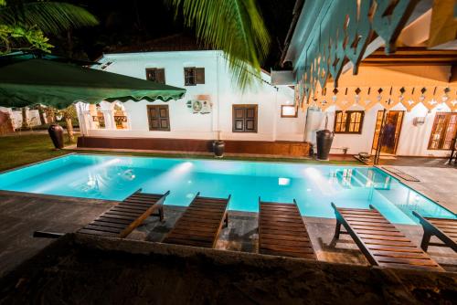 a swimming pool in front of a house at night at Fortress de Jayaweera - Historic Villa Bentota - A proud legacy since 1889 in Bentota