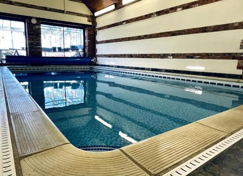a swimming pool with a bench in a building at Silverwood Coach House, with pre booked use of Indoor Swimming Pool in Frome