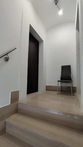 a black chair sitting in a room with a black door at Alle Volte Maison in Grumo Appula