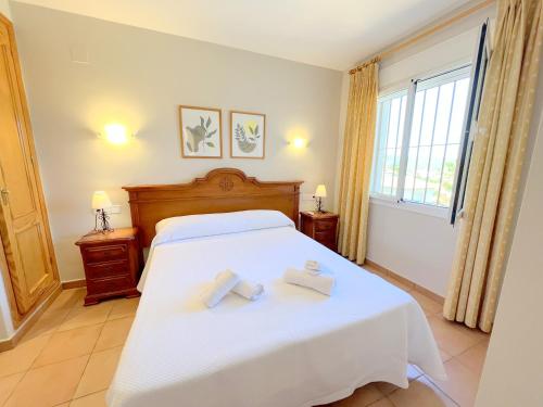 a bedroom with a bed with two towels on it at Villas Monte Jávea - BTB in Jávea