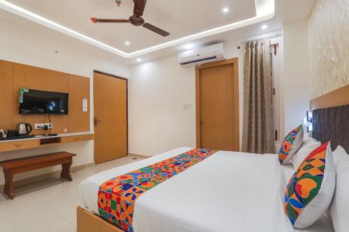 a bedroom with a bed and a television in it at FabHotel Raj Palace in Lucknow