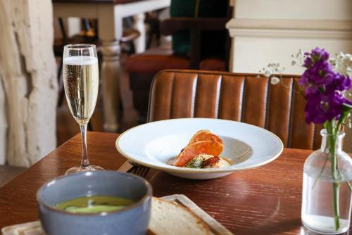 a table with a plate of food and a glass of champagne at The Windmill in Maidstone