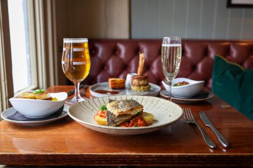 a table with plates of food and glasses of wine at The Windmill in Maidstone