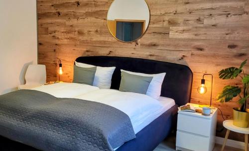 a bedroom with a large bed with a mirror on the wall at HIRSCH FeWo Brocken - Parkplatz - Zentral in Bad Harzburg