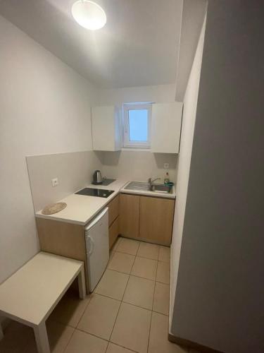 a small kitchen with white cabinets and a sink at Apartments Kristic in Neum