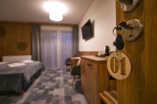a hotel room with a bed and a sign on a door at Willa Marti GOLD in Zakopane