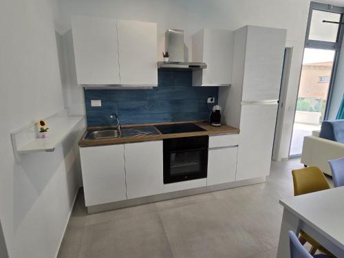 a small kitchen with white cabinets and a sink at SeaMoon Case Vacanze in Sciacca