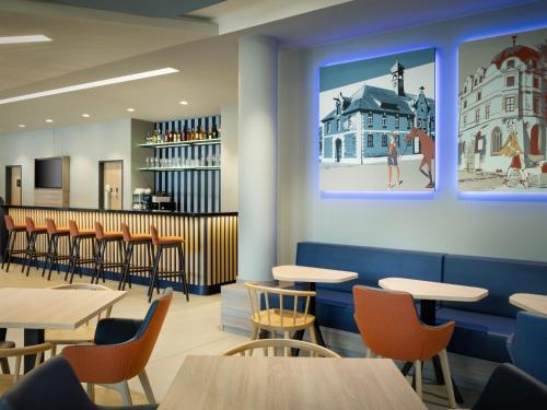 a rendering of a restaurant with tables and chairs at Hampton By Hilton Celle in Celle