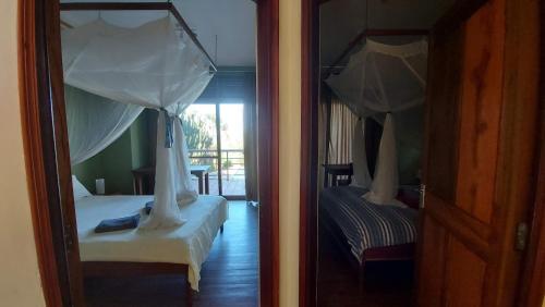 a reflection of a bedroom with a bed and a mirror at Yellow Haven Lodge in Kampala