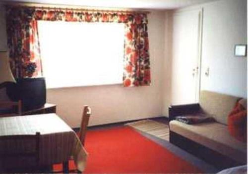 Un dormitorio con una cama y una ventana con suelo rojo. en Ferienwohnung Krüger, en Zirchow