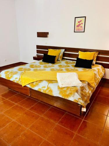 a large bed in a room with yellow and black pillows at Resort Albufeira T1, Praia da Oura in Albufeira