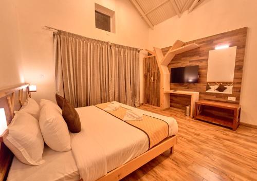 a bedroom with a bed and a television in it at AJ Gable Clouds Ooty by VOYE HOMES - Serene Stay Near Avalanche Emerald Lake in Ooty