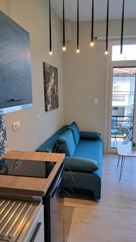 a living room with a blue couch in a room at Bamboo deluxe in Limenas