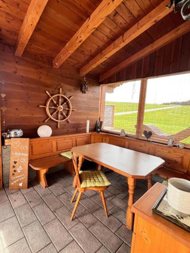a dining room with a wooden table in a cabin at Ferienhaus Praschberg in Niederndorferberg