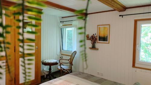 a bedroom with a bed and a table and a chair at Nisihof, Abendblick in Oberkirch