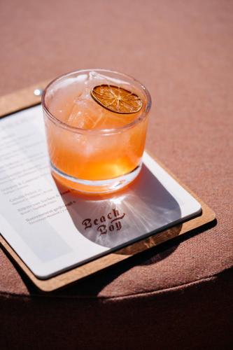 a drink in a glass with an orange on a coaster at Strandhotel in Cadzand-Bad