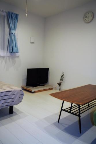 a living room with a table and a couch at The FLAT 103 in Tokyo