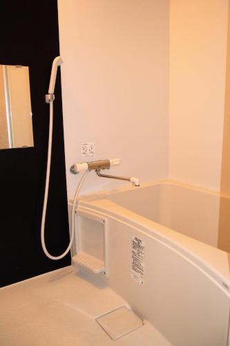 a bath tub in a bathroom with a shower at The FLAT 103 in Tokyo