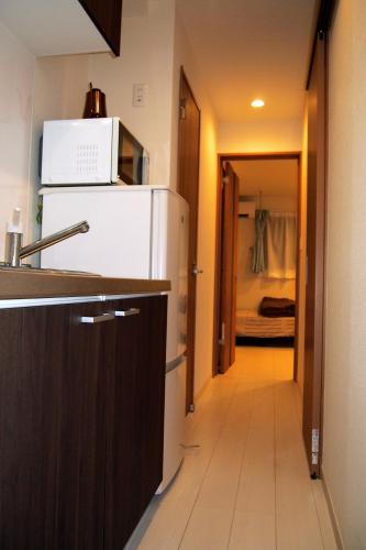 a kitchen with a refrigerator and a microwave at The FLAT 103 in Tokyo