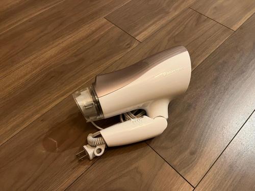 a hair dryer sitting on a wooden floor at The FLAT 103 in Tokyo