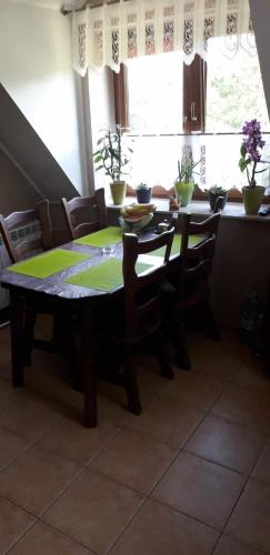 a dining room table and chairs with a table and a window at Zajazd Stok in Górecko Stare