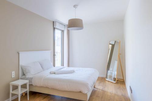 une chambre blanche avec un lit et une fenêtre dans l'établissement OVELIA Troyes - Le Carré Madeleine, à Troyes