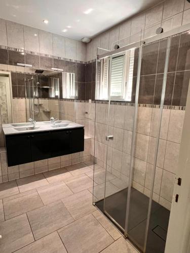 une salle de bain avec une douche en verre et un lavabo dans l'établissement Cap bonheur by Carine, à Lège-Cap-Ferret