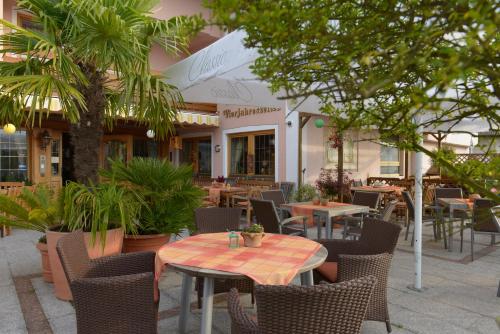 an outdoor patio with tables and chairs and plants at Hotel Vierjahreszeiten in Breitengüßbach