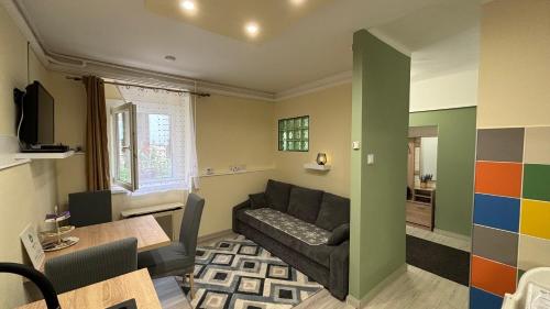 a living room with a couch and a table at Real HOME Apartman in Pécs