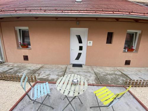 two chairs and a table in front of a house at Real HOME Apartman in Pécs