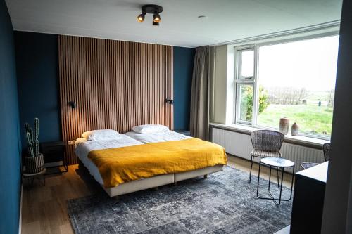 a bedroom with a bed with a yellow blanket at Hotel De Horper Wielen in Kaard