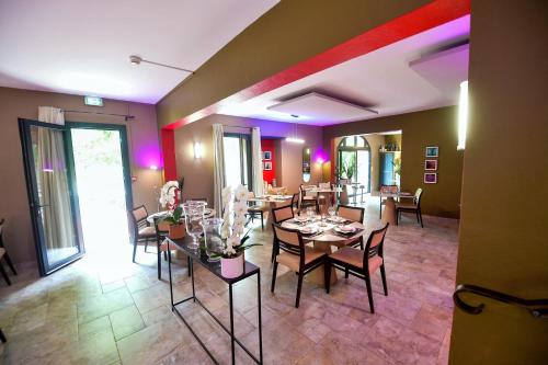 a dining room with tables and chairs in a room at Le Mas Des Aigras - Hôtel & Restaurant de Charme en Provence in Orange