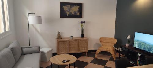 a living room with a couch and a tv at Maison charmante avec patio ! in Bourges