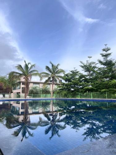 a reflection of palm trees in a swimming pool at UVA Sands Beach Resort in Kundapur