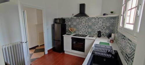 a kitchen with a stove and a refrigerator at Maison charmante avec patio ! in Bourges