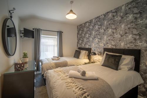 a bedroom with two beds and a stone wall at Pullindoos Self-Catering in Beltoy